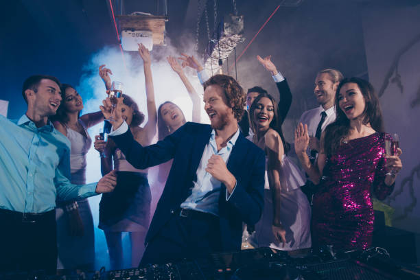 Attractive, handsome man in formal wear dance with glass of beverage against crowd fancy luxury friends