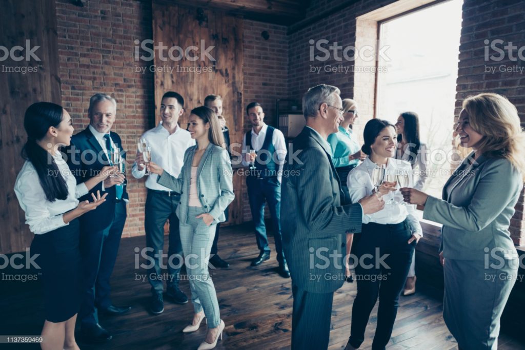 Close up photo business people different age race free leisure excited team building members gathering she her he him his golden beverage toasting best brigade friendship formal wear jackets shirts.